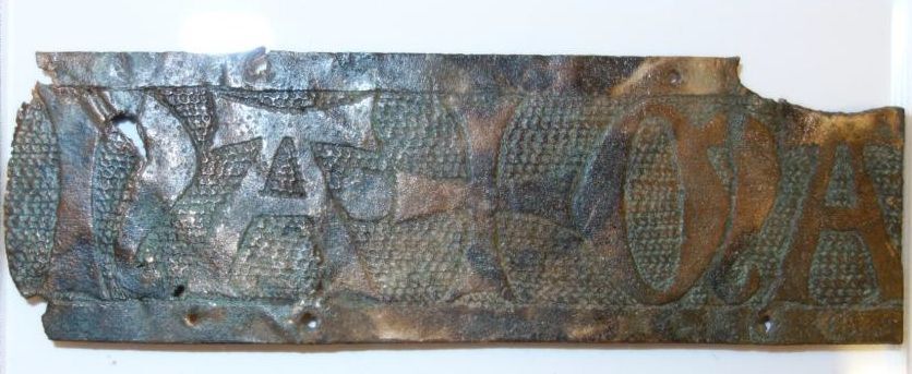 Belegselfragment van een fries met tekst NA•+MA