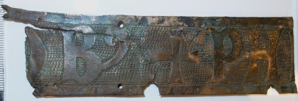 Belegselfragment van een fries met tekst O(?)B+PHI(?)