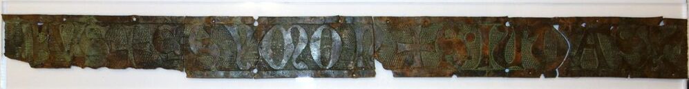 Belegselfragment van een fries met tekst HEUS+S[ANCTA]•SYMON+S[ANCTA]•IUDAS (ornament)+ (?)