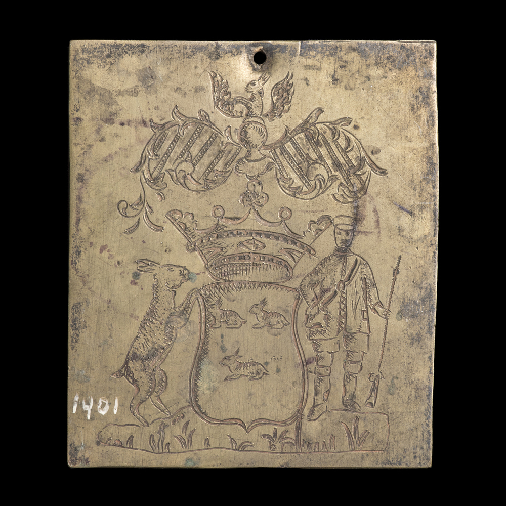 Geel koperen plaatje, waarin gegraveerd een wapen