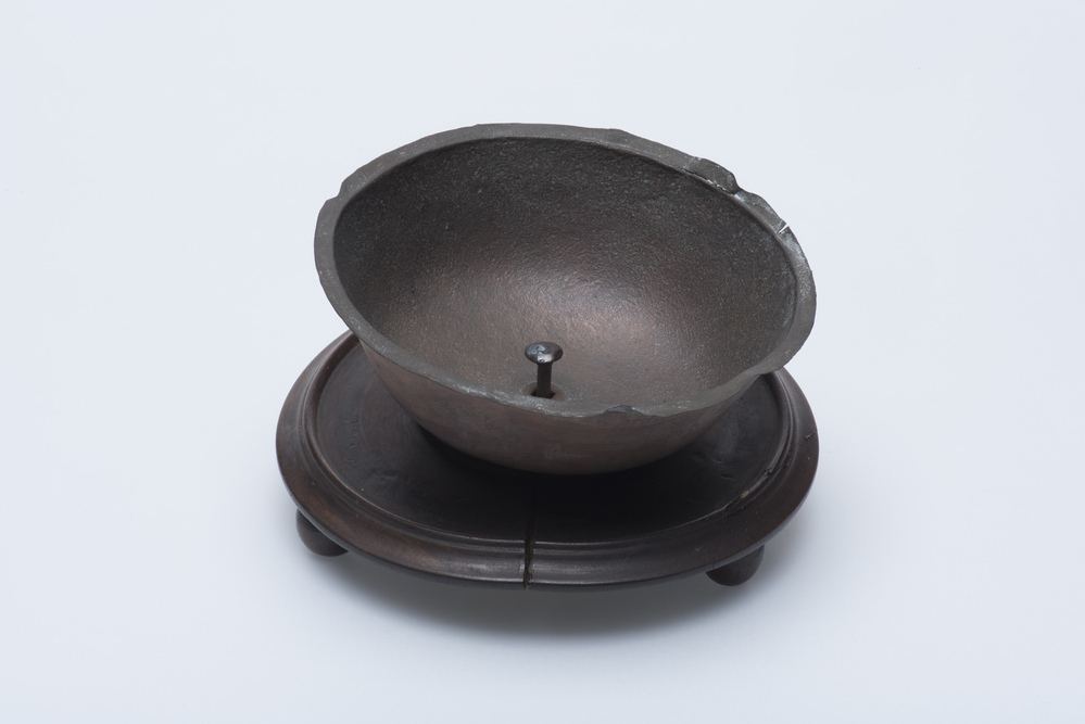 komfoor met koperen bakje op houten voetstukje