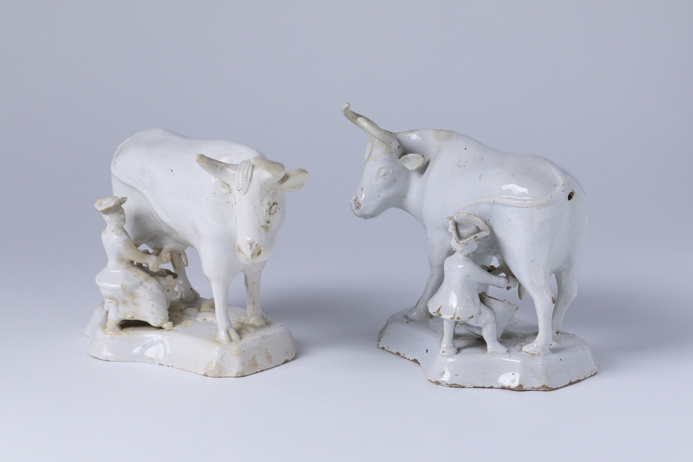 Wit delfts koeien, worden links- en rechtszittend van de koe gemolken