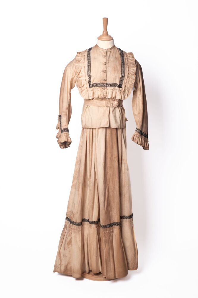 Een japon van katoen, bestaande uit een jak en rok en ceintuur