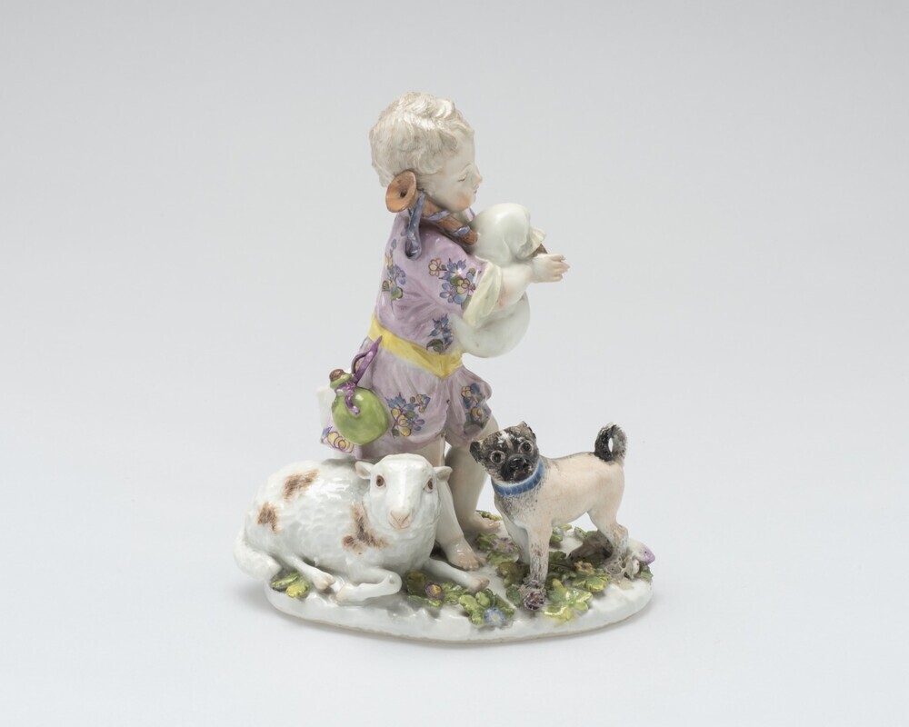 Doedelzak spelende jongen bij schaap en hond