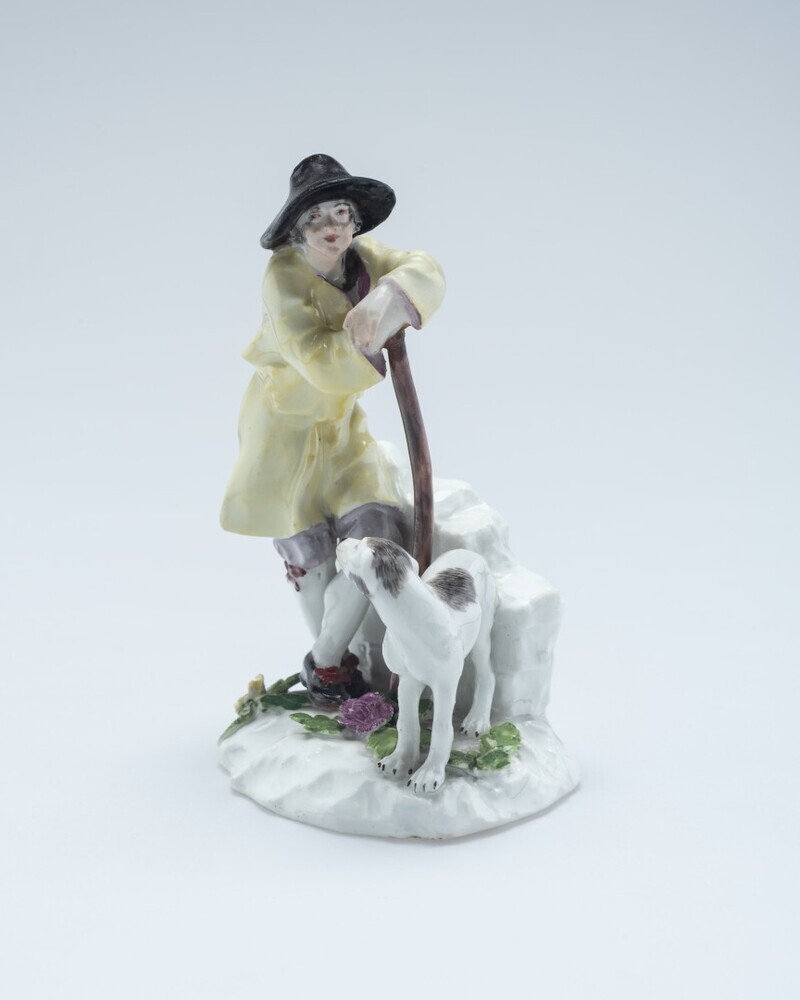 Man, staande met hond bij muurtje