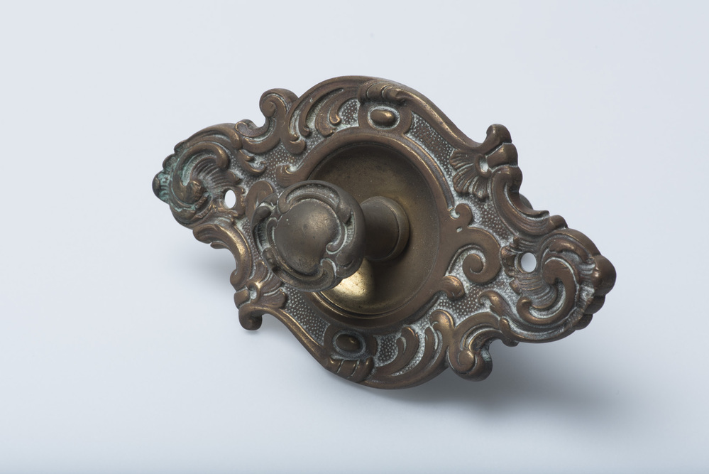 Koperen knop en schild van een deurbel