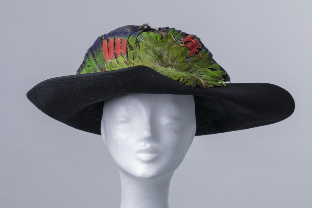Grote diepblauwe vilten dameshoed met papegaaienvleugels