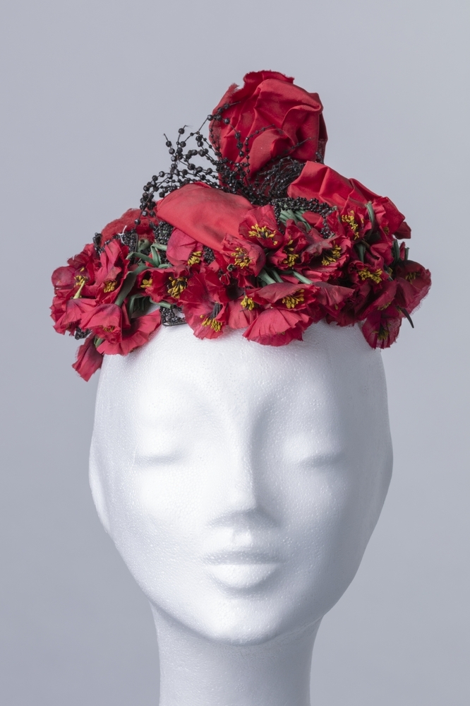Dameshoedje versierd met rood lint en klaprozen