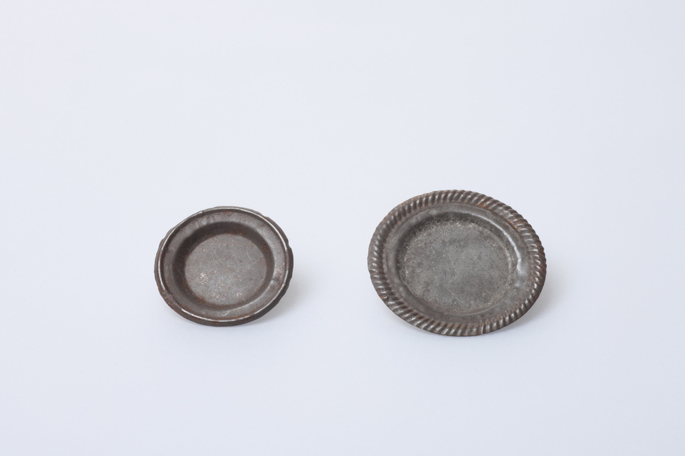 Twee miniatuur bordjes van blik