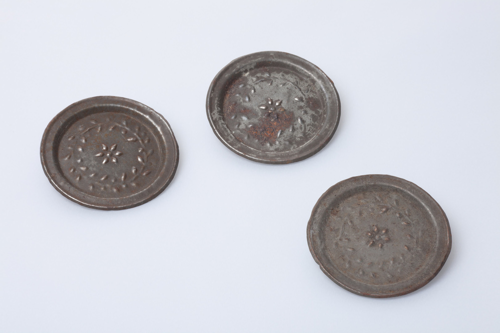 Drie miniatuur bordjes van blik