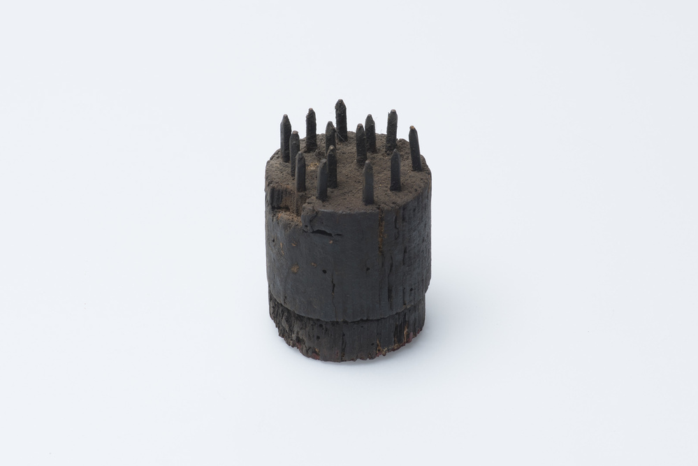 Houten blokje met dikke spijkers