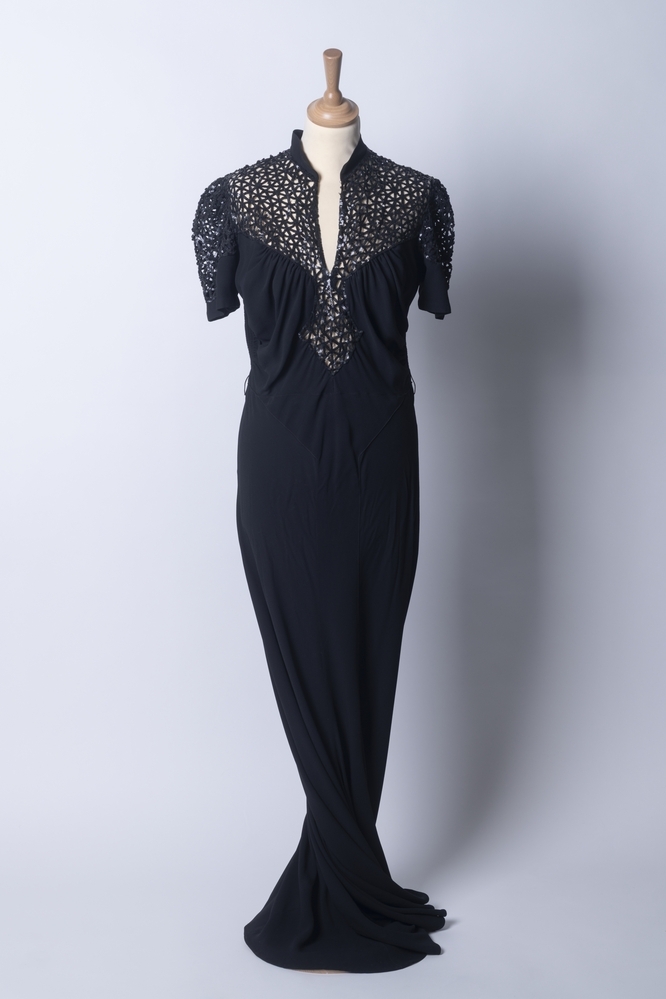 Zwarte avondjapon (met paillettenlijfje) en een (losse) broche