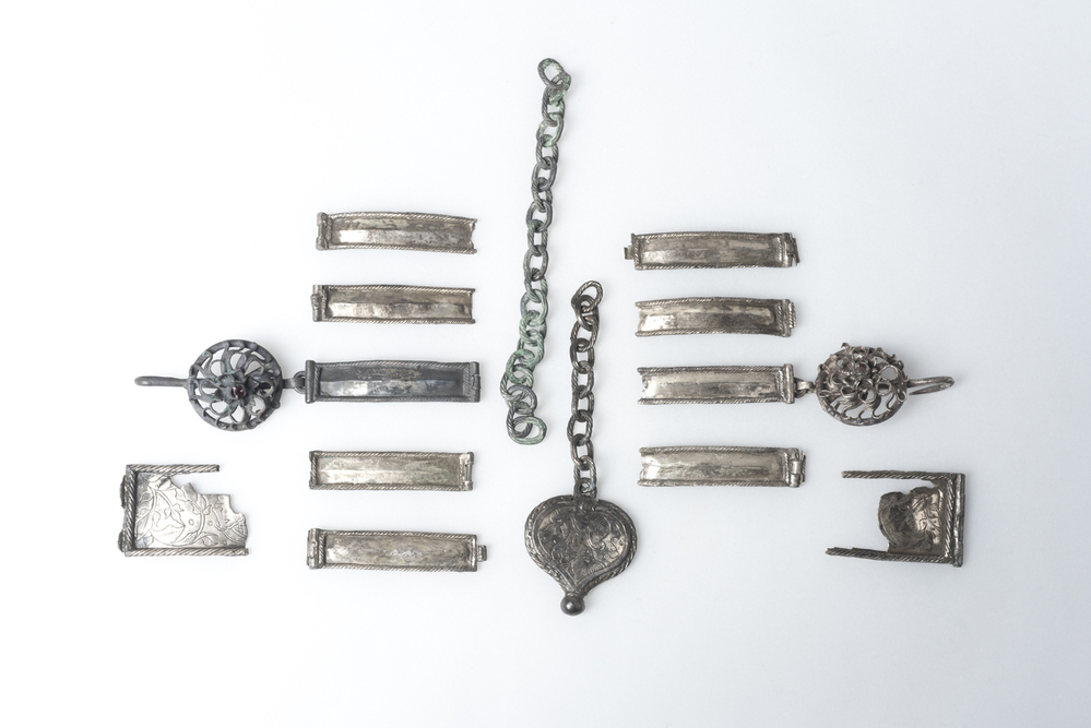Fragmenten van een gordel en van een halsketting (inhoud van aardewerken pot); 16e eeuw. Bodemvondst Pieterburen
