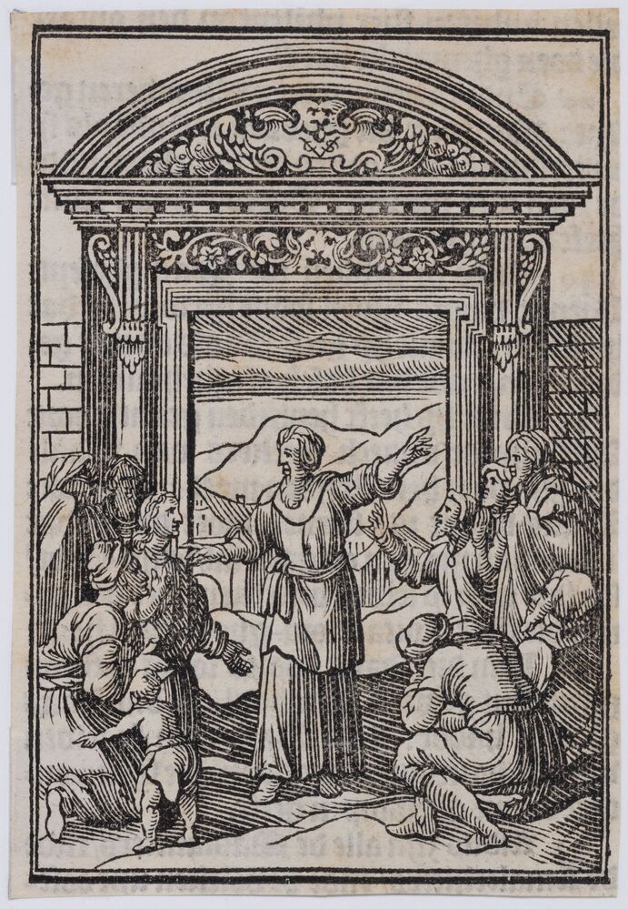 Gebarende man bij poort met omstanders