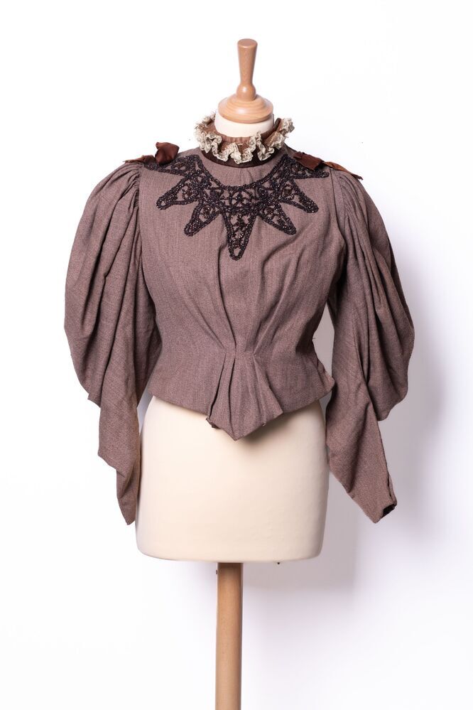 Bruin jak/lijfje versierd met kant, satijn en kraaltjes
