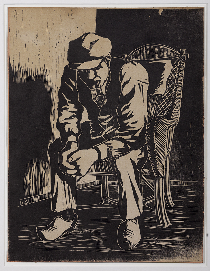 Pijprokende man in rieten stoel