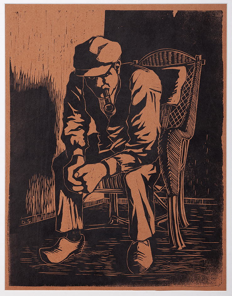 Pijprokende man in rieten stoel