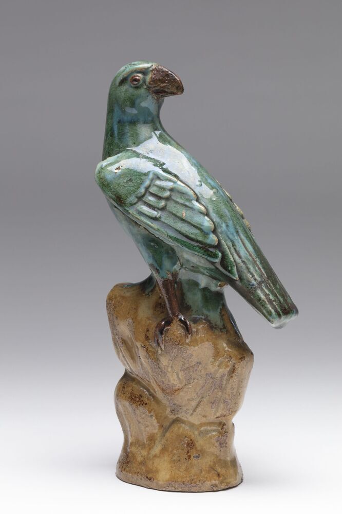 Beeldje van een papegaai op een rots