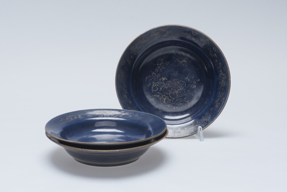 Diep blauw schoteltje met bloemmotieven in goud