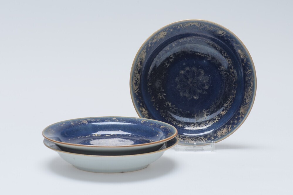 Diep blauw schoteltje met bloemmotieven in goud