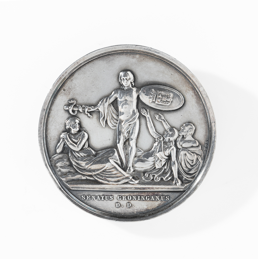 Een bronzen en zilveren Cholerapenning in een cassette