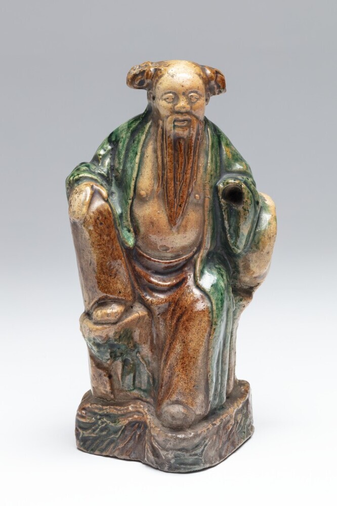 Zittende figuur op een rots