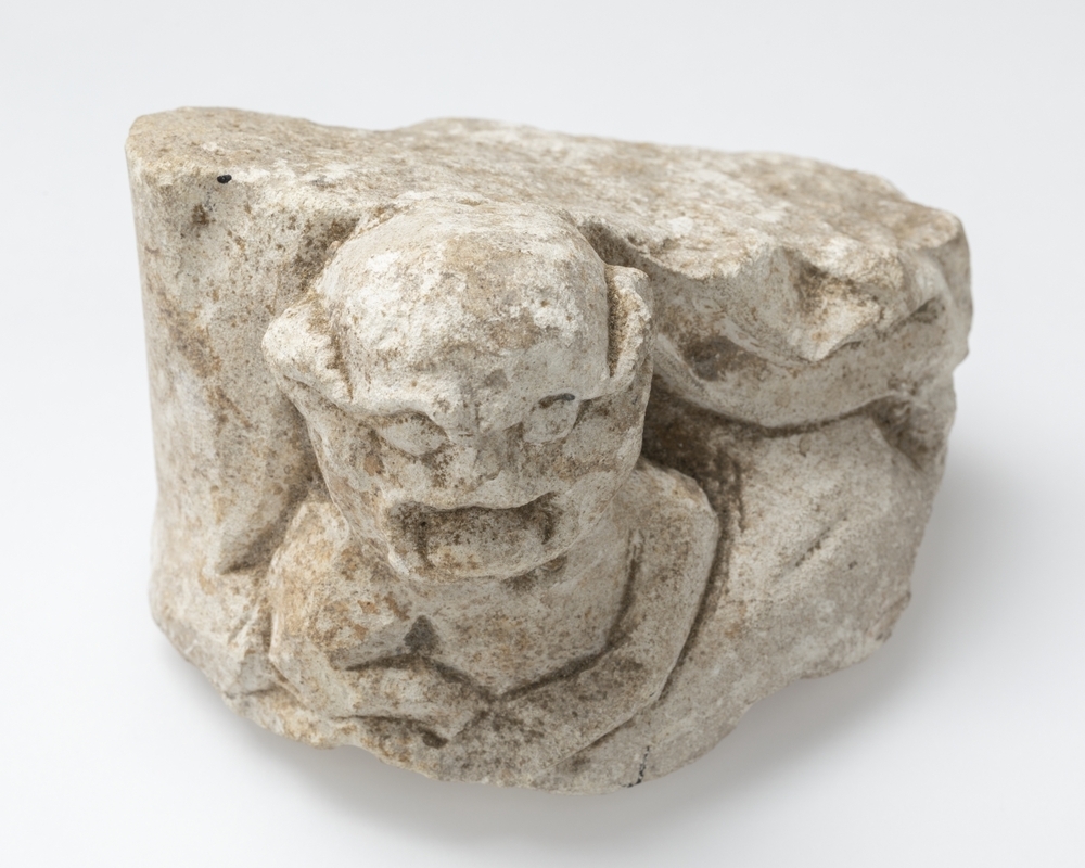 Bouwfragment met demonisch figuur